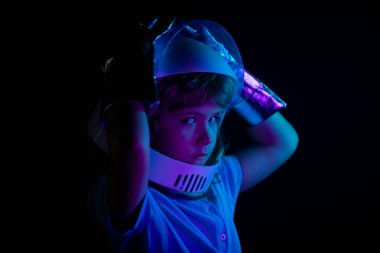 Kapalı çocuk portresi siyah, macera hayalinde izole edilmiş. Çocuk astronotla astronotçuluk oynuyor..