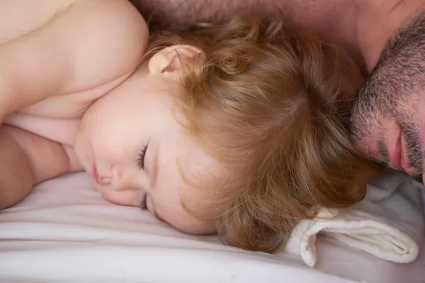 Père et bébé dorment dans le lit. Dormir en famille le matin. Gros portrait somnolent d'enfants. — Photo