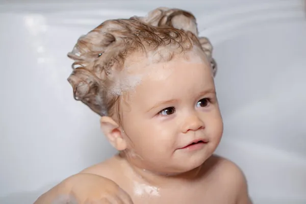 Kind unter der Dusche. Badendes Baby. Glückliches Kind mit Seifenschaum auf dem Kopf. Kind in Badewanne mit flauschiger Seifenblase. — Stockfoto