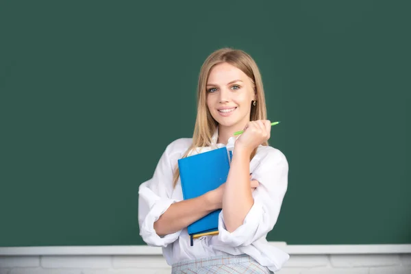 Portrait of female university student study lesson at school or university. Creative young smiling female student with pen and book. — Stock Photo, Image