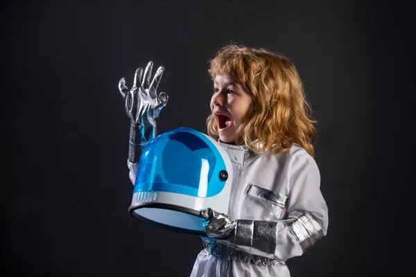 Mignon petit garçon astronaute enfant en combinaison spatiale portant casque sur fond noir. Enfant en costume d'astronaute joue et rêve de devenir un astronaute. — Photo