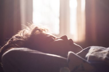 Yatakta uyuyan çocuk. Sessiz bir uyku. Rahat çocuklar sabahları uykulu olurlar. Yüzünü kapat..