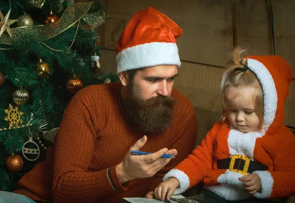 Babbo Natale e bambino all'albero di Natale. Vacanza invernale in famiglia e vacanza — Foto Stock