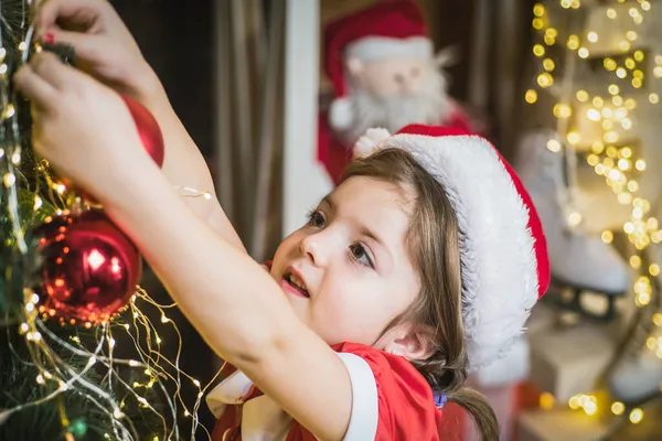 Julgrabb flicka dekorera julgran hemma. — Stockfoto