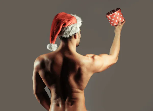 Σέξι Άι-Βασίλης γκέι. Μύες Χριστούγεννα άνθρωπος στο καπέλο ή γυμνό σέξι αθλητικό σώμα, στέκεται με την πλάτη. Σέξι Άγιος Βασίλης — Φωτογραφία Αρχείου