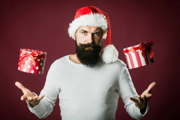 Hombre de Santa con barba y bigote sosteniendo regalo presente sobre fondo rojo púrpura —  Fotos de Stock