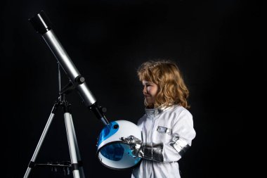 Kasklı küçük astronot portresi ve teleskoplu koruyucu uzay giysisi. Başarı, yaratıcılık ve başlangıç konsepti.