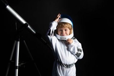 Uzayda sevimli bir astronot çocuk. Çocuk kendini astronot kaskı takmış bir astronot olarak hayal ediyor. Astronot kasklı komik çocuk portresi.