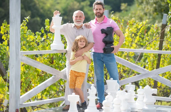 Glücklicher Großvater Vater und Sohn beim Schachspielen. Männer in verschiedenen Altersgruppen beim Schachbrettspiel. Generation der drei Männer. — Stockfoto