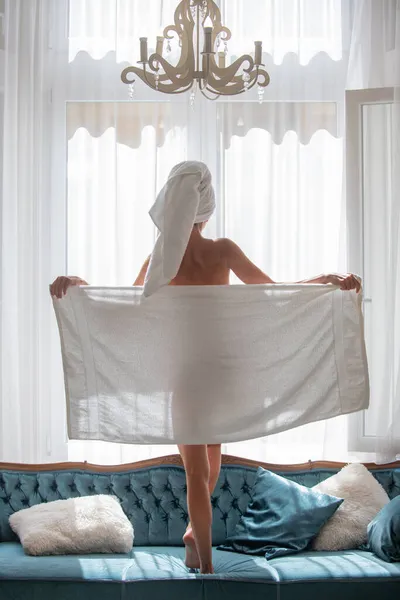 Perfeito corpo de mulher jovem com toalha após o chuveiro. Visão traseira da menina sexy descansando no quarto de luxo uma manhã fácil. Mulher sensual atraente relaxante vestindo roupões de banho e toalhas no quarto de luxo. — Fotografia de Stock