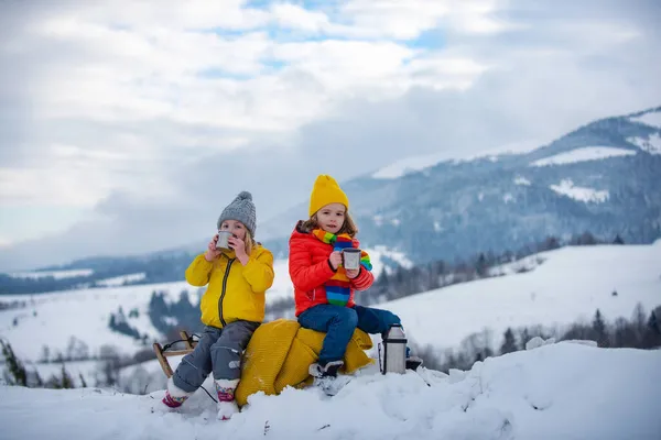 Garçon et fille enfants glissant avec traîneau dans la neige. Enfants actifs en hiver à l'extérieur. — Photo