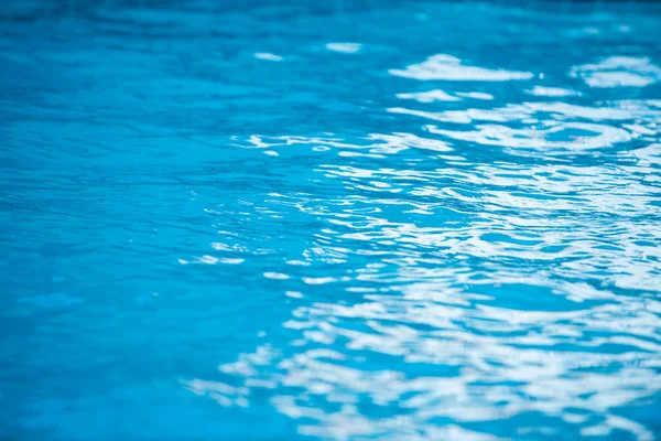 Bakgrund av blått vatten i poolen med sol reflektion, krusning vatten våg i poolen. Klar vatten bakgrund. — Stockfoto
