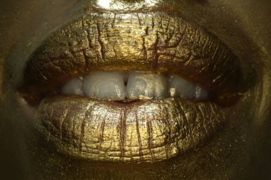 Altın dudaklı makro yakın çekim. Altın dudaklar. Ağızdan gelen altın boya. Makyajlı kadın ağzında altın dudaklar. Altın metalik için duygusal ve yaratıcı tasarım.