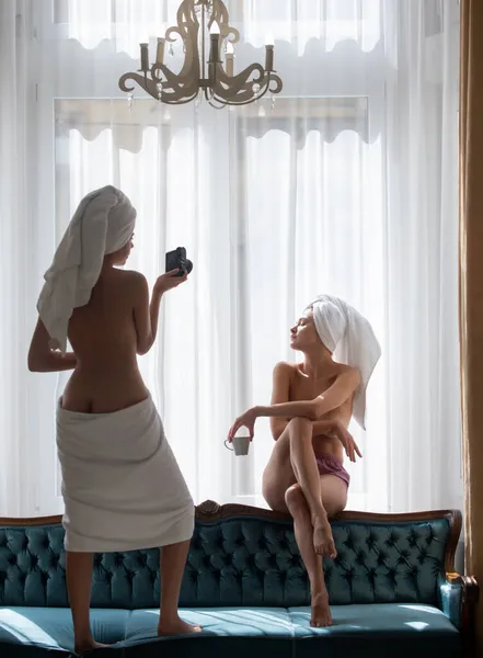 性感的女朋友在公寓或酒店房间里拍照。女摄影师带着相机给女朋友拍照。裸女照片模特. — 图库照片