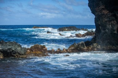 Mavi deniz ve kaya fırtınası. Dalga spreyi taşların üzerinde. Kayalık deniz kıyısı.