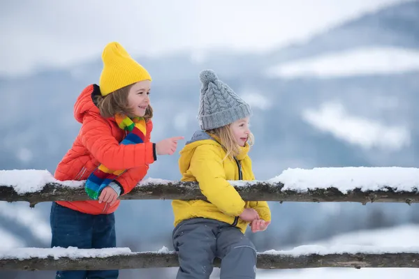 Petite fille et garçon profitant d'une journée à jouer dans la forêt d'hiver. Enfants frères et sœurs s'amusant dans un beau parc d'hiver. Vacances d'hiver enfants à la campagne. — Photo