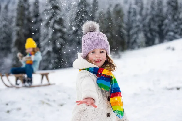 Belle fille enfant jouant au combat de boule de neige sur une promenade d'hiver dans la nature de neige. — Photo