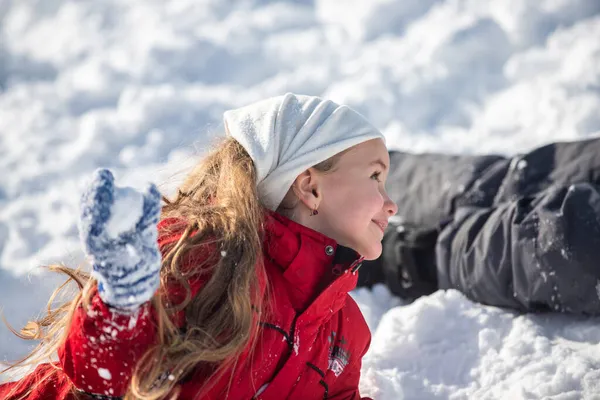 Funny excited child girl face in snow on winter outdoor. Children in winter outdoor in frost snowy day. Amazed kid resting together in park with winter background. Expressive kids emotions. — Stock Photo, Image