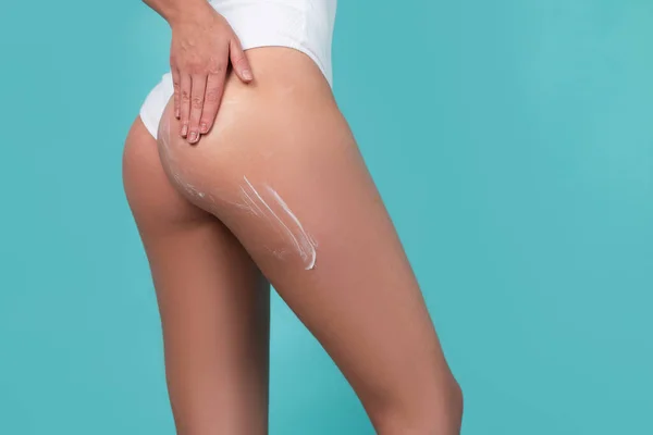 Cosmetic cream on woman buttocks with clean soft skin. Applying moisturizer cream on butt. Cellulite or anti cellulite treatment. Body care and spa salon concept, isolated. — Stok fotoğraf