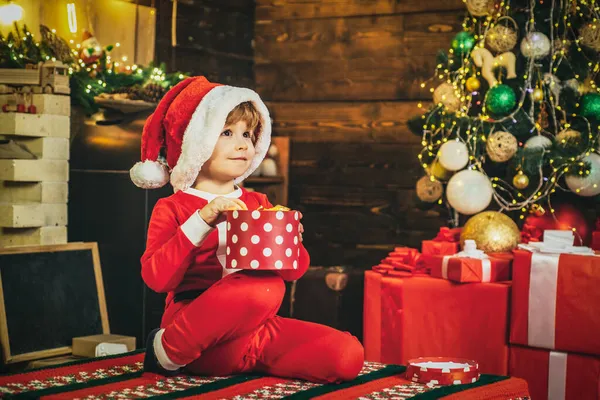 冬服を着た子供はクリスマスツリーの近くのサンタを考える。子供のためのメリークリスマス. — ストック写真