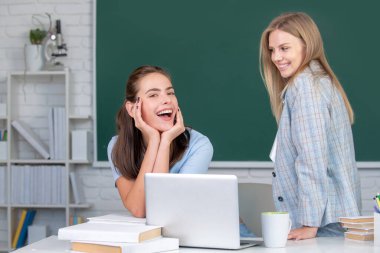 Öğrenci kızlar okuldaki sınıfta birlikte okuyorlar..