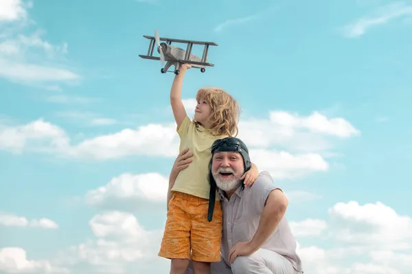 Torunum ve büyükbabam, oyuncak jetleriyle gökyüzüne doğru uçuyorlar. Seyahat hayali kuran çocuk pilot pilot.. — Stok fotoğraf