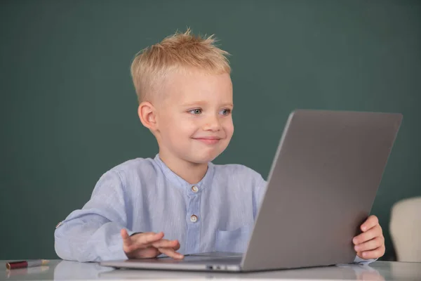 Portrét atraktivního veselého chlapce s notebookem. Malý zábavný programátor. — Stock fotografie