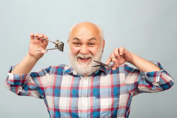 Старий перукар. Щасливий старий бородатий чоловік, бородатий чоловік з ножицями і прямий затискач для волосся з бритви . — стокове фото