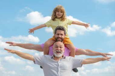 Babalar Günü. Aile babası, hafta sonları farklı yaşlarda. Büyükbabası olan baba ve oğlu el kaldırıyor ya da kollarını açıp uçuyor. Erkekler üretimi.