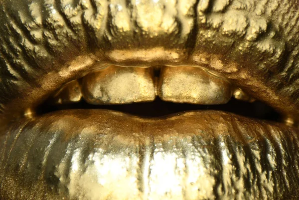 Macro fechar lábios de ouro. Tinta dourada da boca. Lábios dourados em boca de mulher com maquilagem. Design sensual e criativo para metal dourado. — Fotografia de Stock