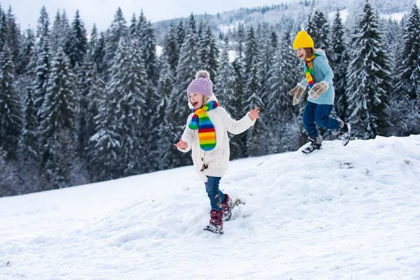 Söt liten flicka som springer på snö vinter natur. Rolig unge leker med snö i vinterkläder. Barn vinter utomhus. Barn Jul semester. — Stockfoto
