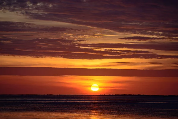 Sunset playa del océano. Salida del sol brillante con sol amarillo bajo la superficie del mar. — Foto de Stock