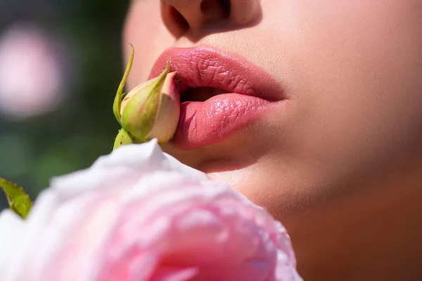 Σέξι Χείλη. Ομορφιά κόκκινα χείλη μακιγιάζ λεπτομέρεια. Χείλη με ανοιξιάτικα λουλούδια κοντά. Όμορφη γυναίκα χείλη με τριαντάφυλλο. — Φωτογραφία Αρχείου
