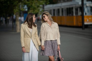 Kafkasyalı mutlu genç kadınların güzel günlerin tadını çıkardıkları açık hava portresi. Güzel genç kızlar birlikte dışarıda eğleniyorlar. Yaşam tarzı şehir havası. En iyi arkadaşlar günlük kıyafetler giyer..