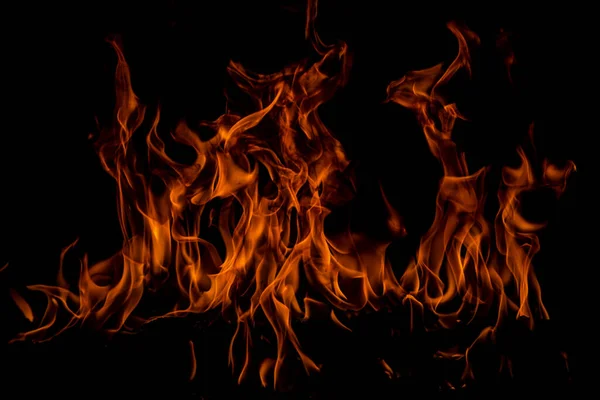 Feuerflamme brennt und Feuer glüht auf schwarzem Hintergrund. — Stockfoto