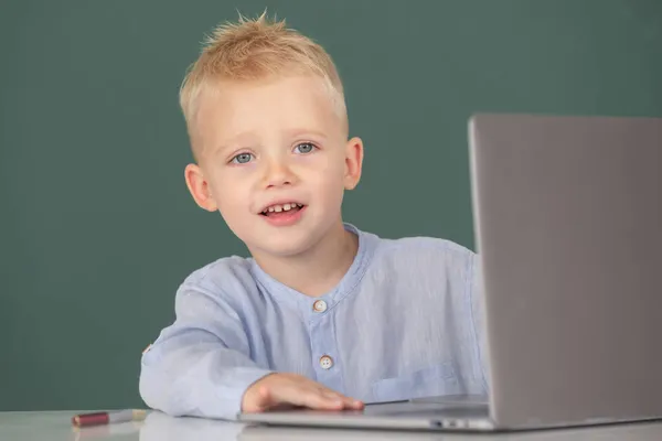 Slimme jongen die online leert in de klas. Klever kind bestudeert online videogesprek met zoom. Leerling kind leren Engels taal online met laptop op school. — Stockfoto