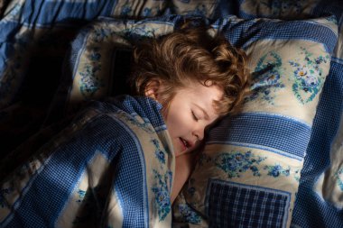 Yatakta uyuyan çocuk. Sevimli küçük çocuklar uyuyorlar. Güzel, sağlıklı, huzurlu bir uyku çekiyorlar..