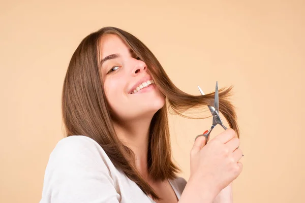 Szczęśliwa kobieta z nożyczkami obcinającymi włosy. Piękna dziewczyna z prostymi włosami z profesjonalnym nożyczkiem, odizolowana. Koncepcja pielęgnacji włosów. — Zdjęcie stockowe