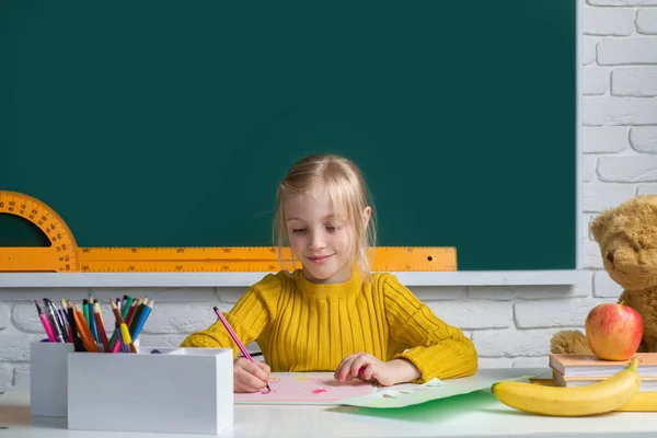 Aranyos gyerek, az általános iskola osztálytermében tanul. Oktatás, tanulás és gyermekkoncepció. — Stock Fotó