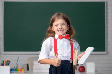 Sınıfta üniformalı şirin, sevimli bir kızın portresi..