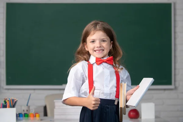 Porträt eines niedlichen, lieblichen Mädchens in Schuluniform im Klassenzimmer. — Stockfoto