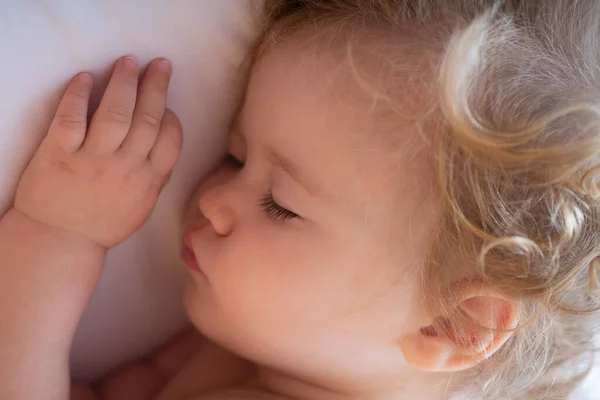 Söt baby barn sover i sängen. Närbild sömniga barn ansikte. — Stockfoto