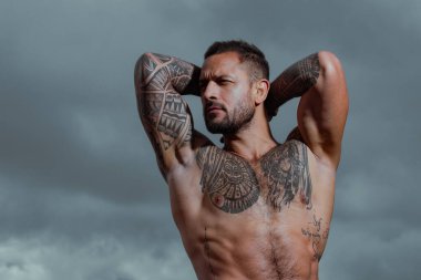 Çıplak gövdeli seksi adam. Ciddi yüzlü yakışıklı bir adamın portresi. Güçlü kaslı erkek vücudu, kaslı adam. Çıplak erkek omuzları, üstsüz atletik vücudu..
