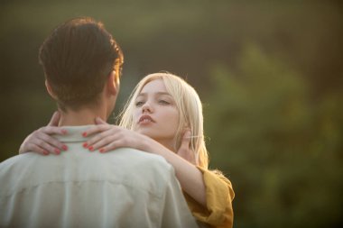 Sarılıp kucaklaşan genç aşıklar. Gün batımında sarılıp öpüşen aşıklar. Sevgi ve şefkat dolu bir çift..