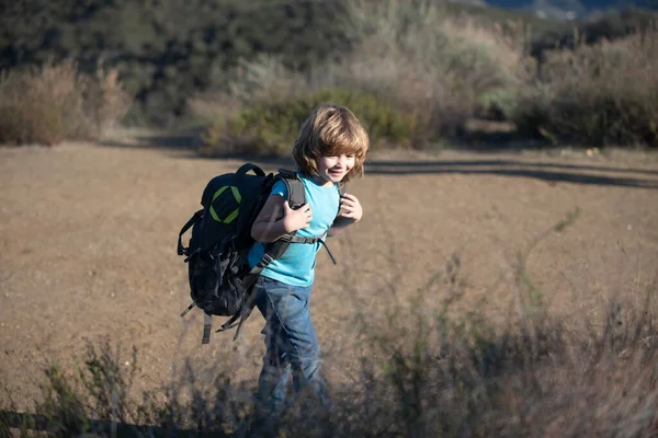 Chłopiec na kempingu z plecakiem wędrówki. Mały turysta idzie na wycieczkę. — Zdjęcie stockowe