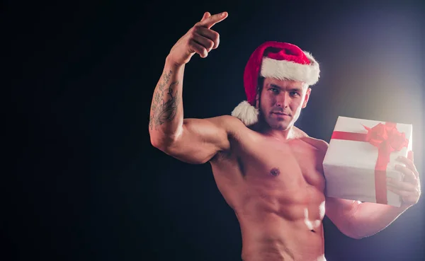 Sexy shirtless Santa com presente no fundo preto, espaço para texto. — Fotografia de Stock