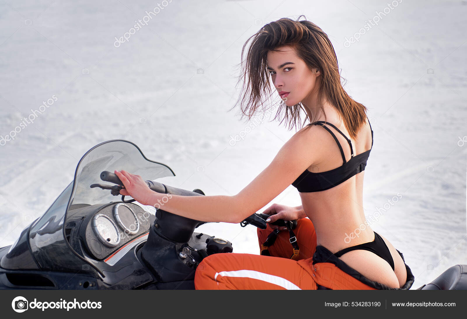 Sexy woman driving snowmobile in snowy winter image