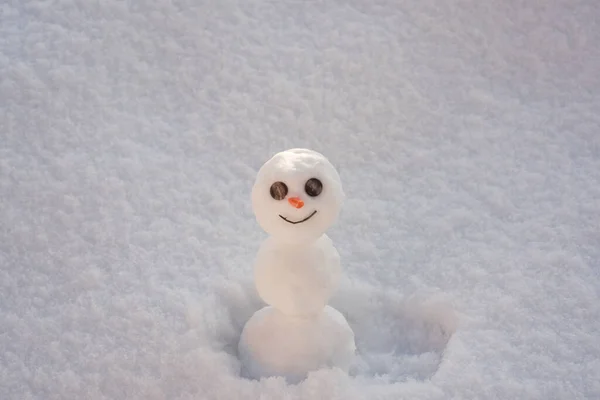 Hombre de nieve. Muñeco de nieve en el fondo de la textura de los copos de nieve. — Foto de Stock