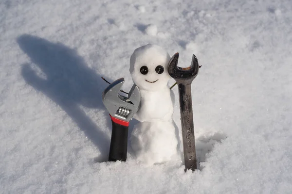 Hóember. Vicces hóember egy havas réten, hófödte háttérrel. Csavarhúzó és csavarhúzó. Támogatás javítása és karbantartása. — Stock Fotó