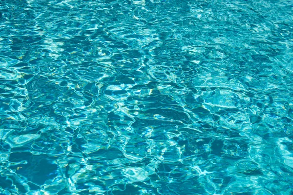 Vattenbakgrund. Blått vatten, ringar och slingor. Konsistens på vattenytan och klinkerbotten. — Stockfoto